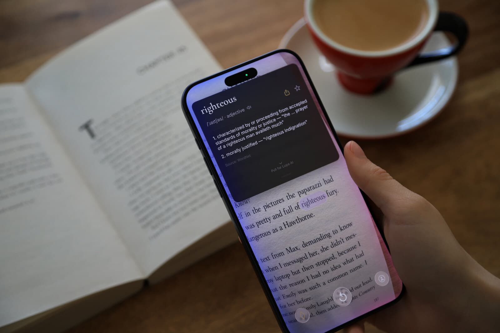 Close-up of the Lupa definition card showing 'righteous' with pronunciation and two definitions over the live camera view of a book